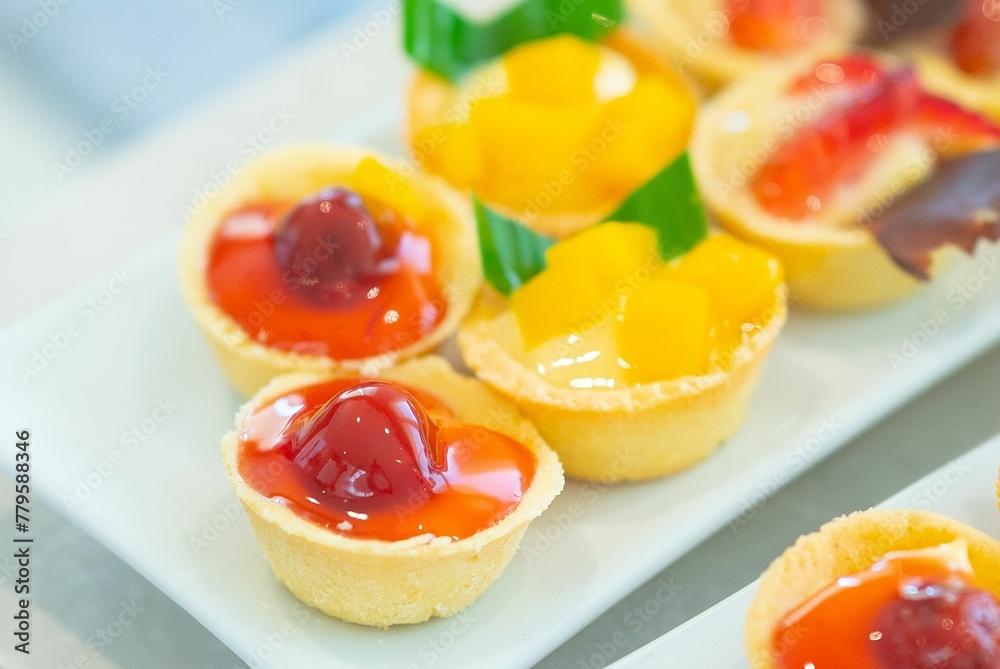 Closeup shot of tasty and sweet tartlets with fruits put on the white plate