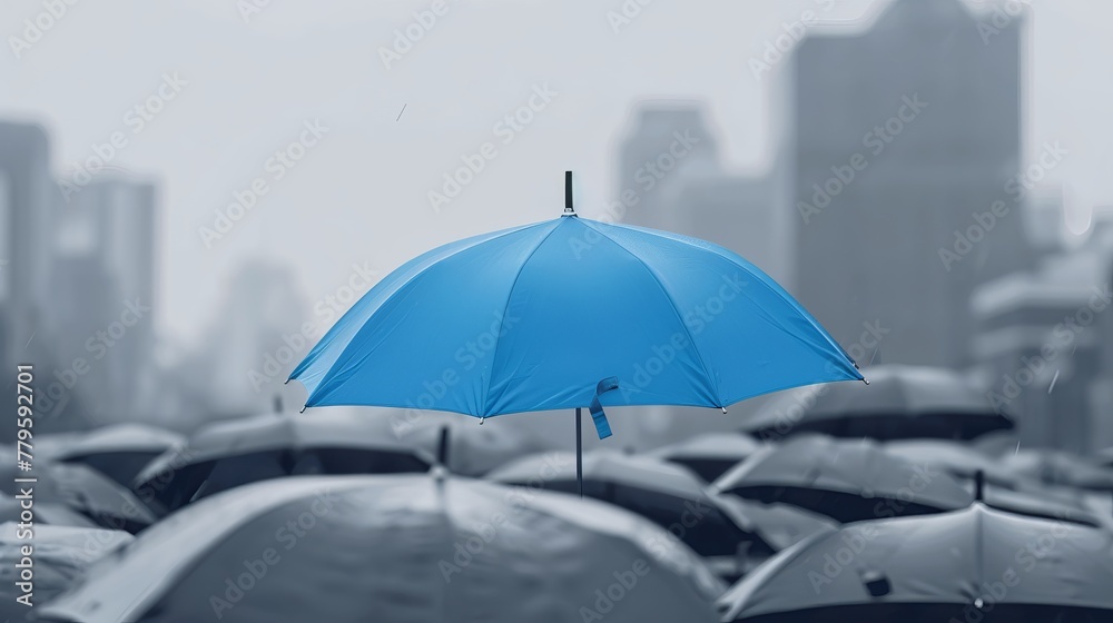 A blue umbrella stands out atop a collection of gray umbrellas against a city background, symbolizing business safety and protection concepts