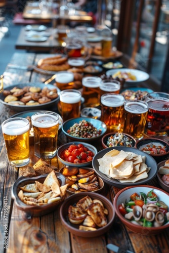 Table with beer and snacks for a large group. Lots of different food for meeting friends in a pub or beer bar © Daniil