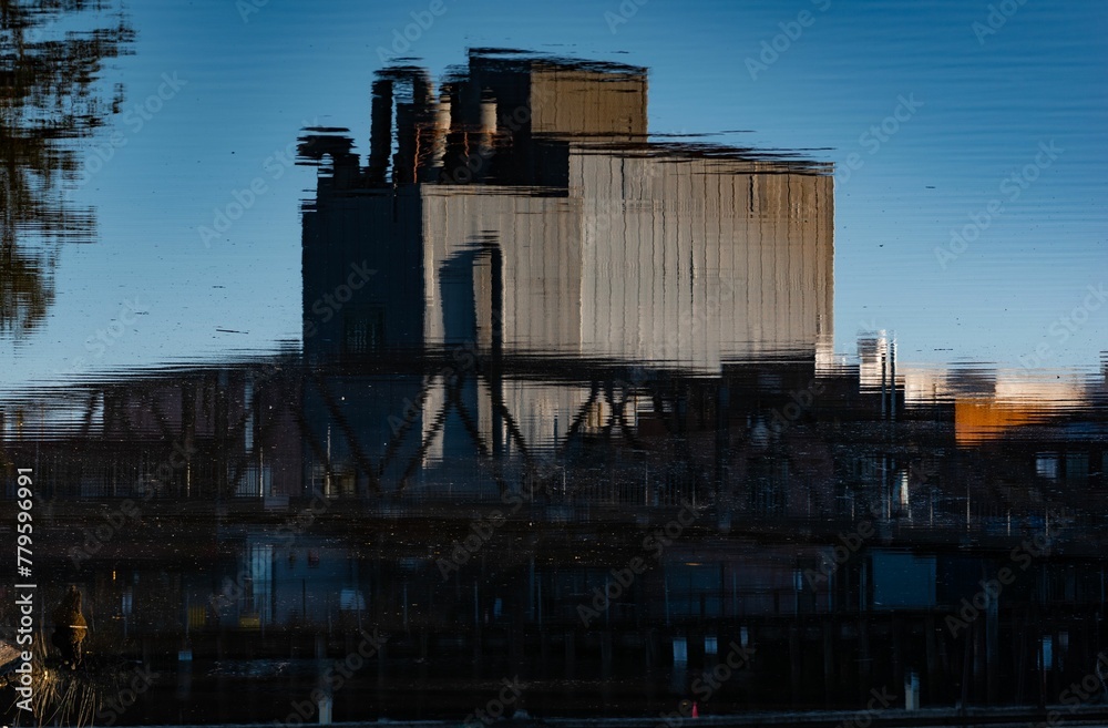 Reflection of an industrial building in a river water