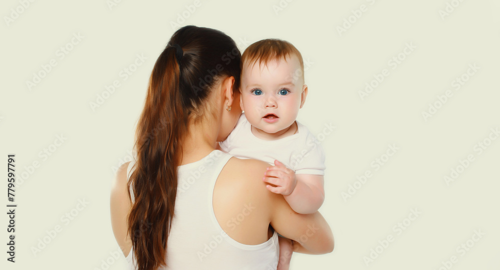 happy young mother holding baby on white studio background happy young mother holding baby on white studio background