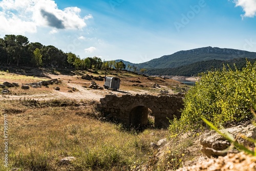 Stone bridge in a desolated place with green hills on the background photo