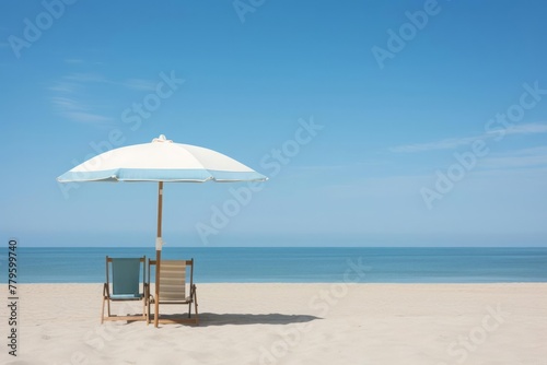 Oceanfront relaxation, showcasing a simple beach umbrella planted firmly in the sand. The tranquil ocean stretches to the horizon under a clear sky, evoking a sense of calm and tranquility. © DK_2020