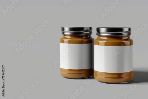 Two identical jars of creamy peanut butter with blank labels on a simple grey background. Twin Jars of Natural Peanut Butter with Labels