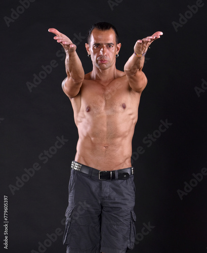 Sexy portrait of muscular handsome topless male model posing in studio