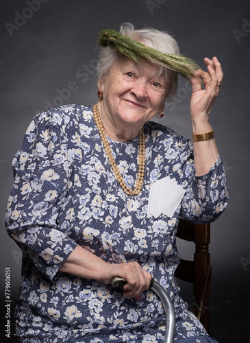 Smiling elderly woman with wreath on head posing in studio
