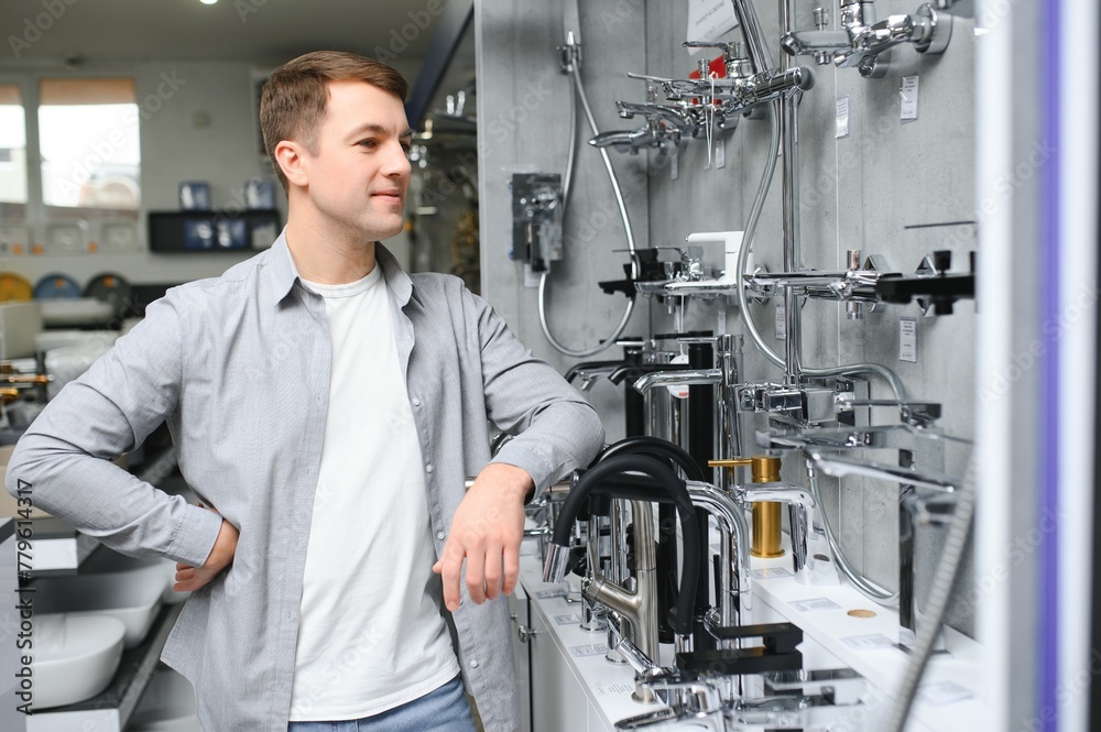 A buyer shopping for bathroom equipment in hardware store. Touching faucet crane or water tap A buyer shopping for bathroom equipment in hardware store. Touching faucet crane or water tap
