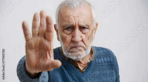 Disapproving Elderly Man Making Dismissive Gesture Against White Background photo