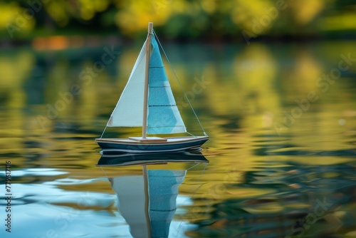 Handmade remote control sailboat reflecting on lake