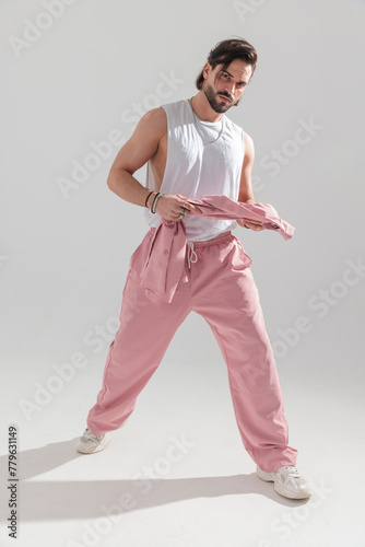 sexy muscle man wearing pink sport clothes holding jacket and walking