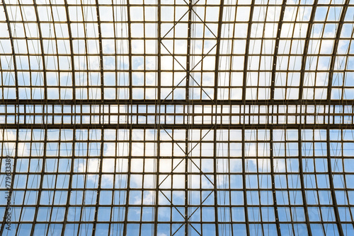 Sky with clouds through the glass arched ceiling of a modern building. Architectural concept of open space.