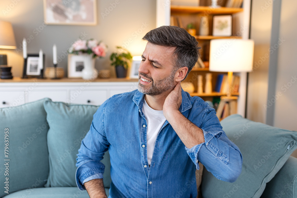 Handsome man touching his neck, suffering from neck pain, sciatica, sedentary lifestyle concept. neck health problems. Healthcare, insurance Handsome man touching his neck, suffering from neck pain, sciatica, sedentary lifestyle concept. neck health problems. Healthcare, insurance