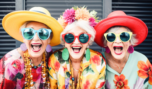 Outdoor portrait of females old aged friends together with sunglasses having fun. Group of mature women friends posing for a photo in summer outdoor in a leisure activity. Forever young concept. 