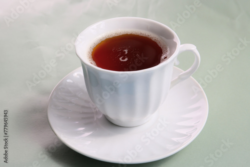 cup of hot black tea on a bright spring colors background