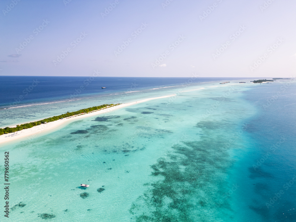 Aerial view of the Dhigurah island in the Maldives famous for its long white sand beach lined with palm trees in the south Ari atoll