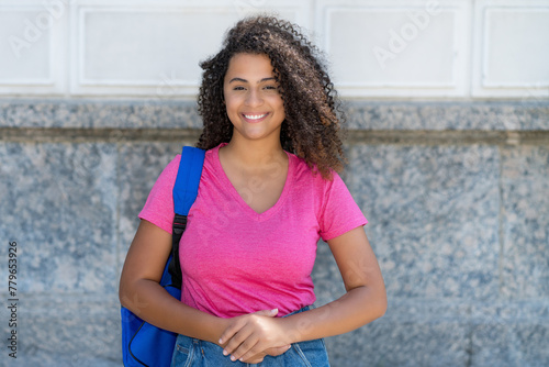 Beautiful laughing latin american female student with backpack