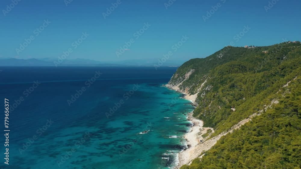 Stunning aerial view capturing the vivid blue waters along a dense, green coastline with a clear sky overhead, evoking a sense of tranquility. Stunning aerial view capturing the vivid blue waters along a dense, green coastline with a clear sky overhead, evoking a sense of tranquility.