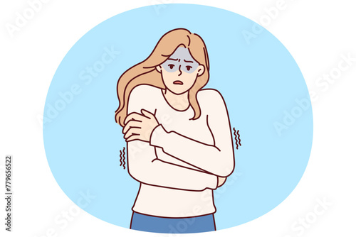 Freezing woman hugging shoulders trying to keep warm and feeling chills after contracting flu infection or fever. Freezing girl in sweater dreams of warm house to wait out cold weather