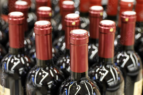 Wine bottles in a row, selective focus. Liquor store, red wine production and retail © Oleg
