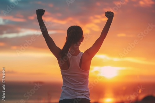 A woman joyfully raises her arms in the air against the backdrop of a beautiful sunset, A person achieving their fitness goal, filled with triumphant emotion, AI Generated