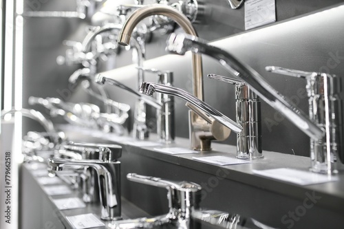 Water taps of different types and shapes on the counter in the store. Retail trade in sanitary ware. Foreground.
