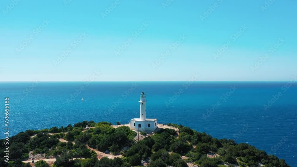 A tranquil seascape with a white lighthouse on a headland, surrounded by lush green foliage and the expansive blue sea under a clear sky. A tranquil seascape with a white lighthouse on a headland, surrounded by lush green foliage and the expansive blue sea under a clear sky.