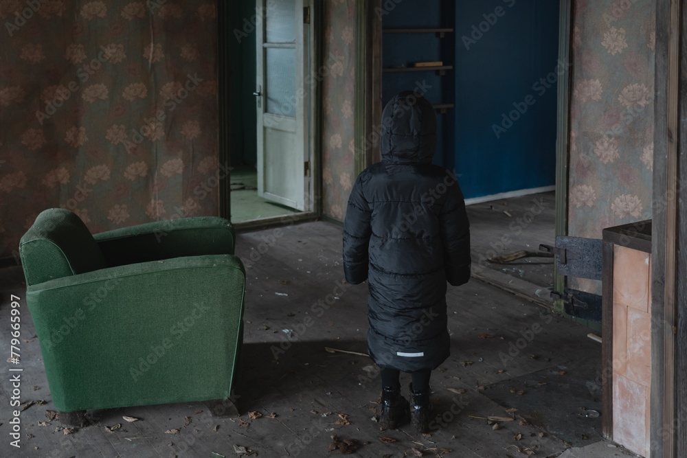 A child in a black coat entered an abandoned house. A child in a black coat entered an abandoned house.