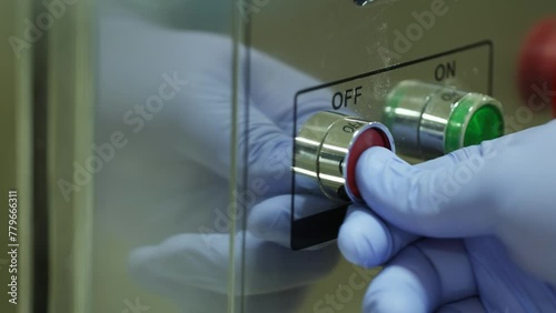 Man in protective gloves setting up scientific equipment. photo