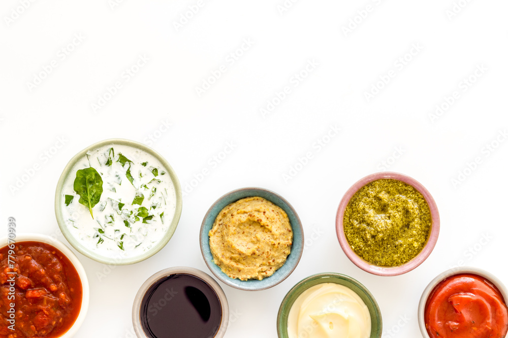 Set of sauces in bowls - pesto salsa mustard and others. Food background