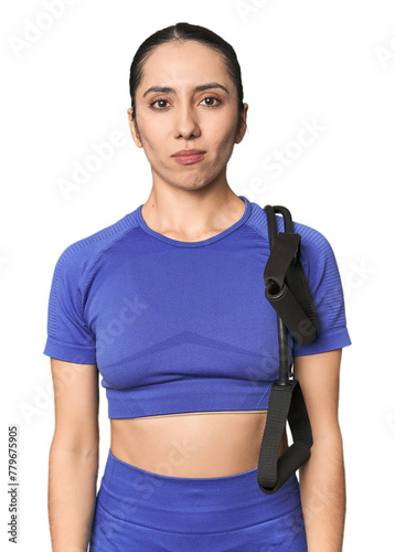 Athletic young Caucasian woman with resistance band on studio background screaming very angry and aggressive.