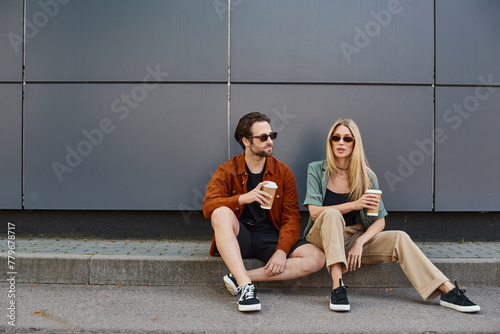 Foto couple engaged in a romantic moment, sitting on the curb with coffee