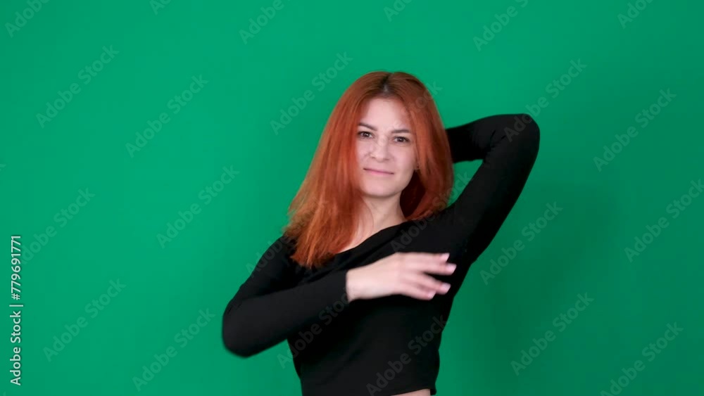 A red-haired girl in black clothes raises her hands up and lowers her hands, stroking her hair. A red-haired girl in black clothes raises her hands up and lowers her hands, stroking her hair.