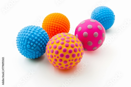Five vibrant rubber balls for dogs on a white surface