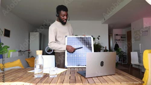 man explaining through his laptop on a video call the working of new sustainable products while speaking into the microphone with his headphones - affordable solar panel concept