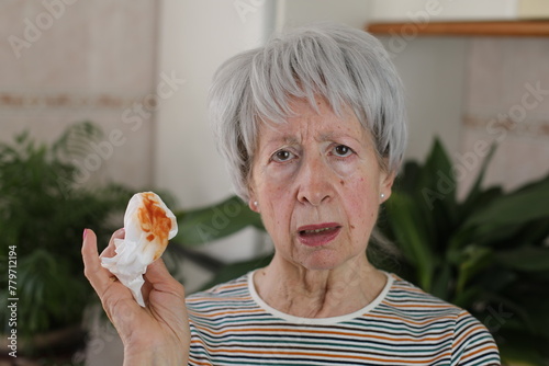 Senior woman coughing saliva with blood  photo