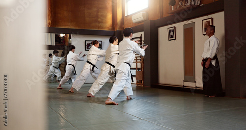 Aikido, black belt and fight class with sensei training or teaching athletes for self defence exercise. Dojo, students and people in a gym or studio for workout, practice and fitness routine in Japan