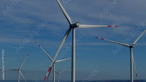 Green energy, wind turbines produce energy in the mountains landscape with blue sky on background, modern power plant, alternative energy sources.