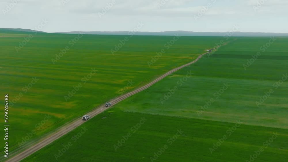 Drone is following to a cars which is rides on the road among agricultural fields. Adventuring on the car. Top view onto moving car. The concept of travel. Drone is following to a cars which is rides on the road among agricultural fields. Adventuring on the car. Top view onto moving car. The concept of travel.