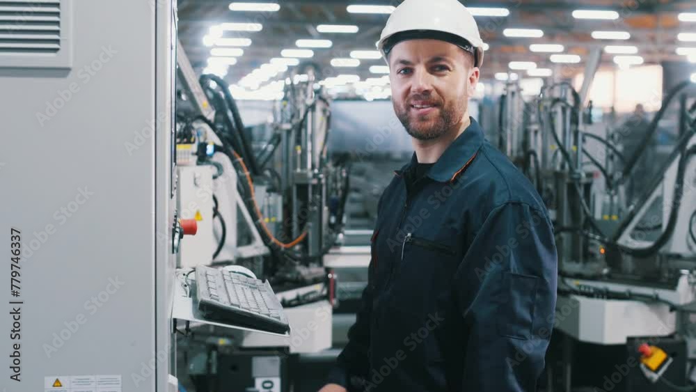 Adjusting settings of machine, operating. Factory worker is indoors with hard hat. Adjusting settings of machine, operating. Factory worker is indoors with hard hat.