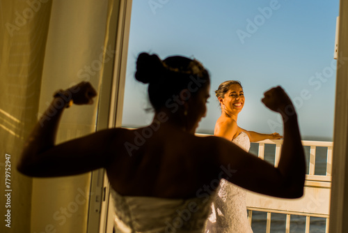 mujeres jovenes latinas sonriendo mientras una de ellas hace un gesto de fuerza con sus brazos 