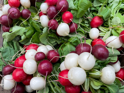 Multicolored red, purple and white fresh radishes at the market close up photo