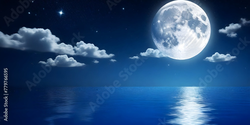 The full moon is shining brightly in the night sky, casting its reflection on the calm surface of the body of water below photo