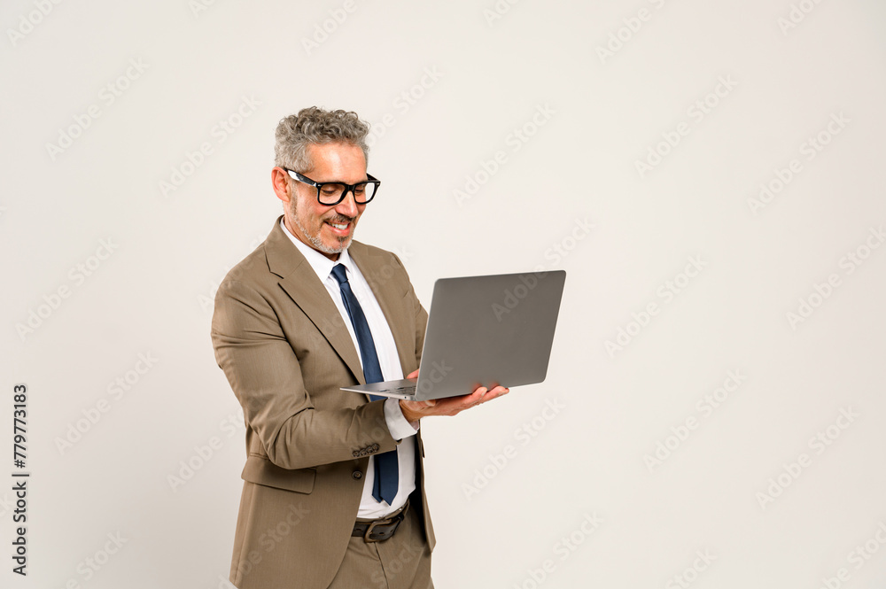 Experienced businessman beams at laptop screen, his formal suit and blue tie portraying a perfect blend of professionalism and approachability. Successful online negotiations and client interactions Experienced businessman beams at laptop screen, his formal suit and blue tie portraying a perfect blend of professionalism and approachability. Successful online negotiations and client interactions