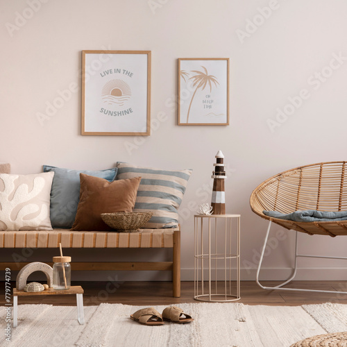 Interior design of cozy and summer living room with rattan armchair, couch, pillows, mock u poster frame, side table, bamboo ladder, decoration, carpet and personal accessories. Stylish home decor. © FollowTheFlow