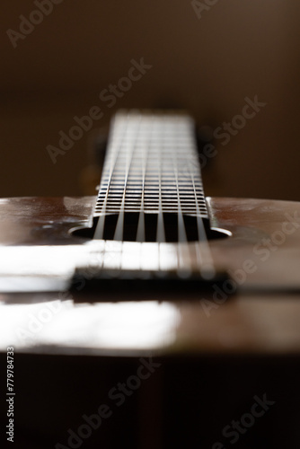 Ausschnitt Nahaufnahme mit Tiefenschärfe scharf unscharf close-up einer staubigen spanischen Flamenco Gitarre 
