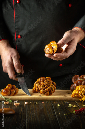 The cook preparing fresh velvet foot mushrooms in restaurant kitchen. The concept of preparing dietary wild mushrooms Flammulina velutipes for breakfast photo