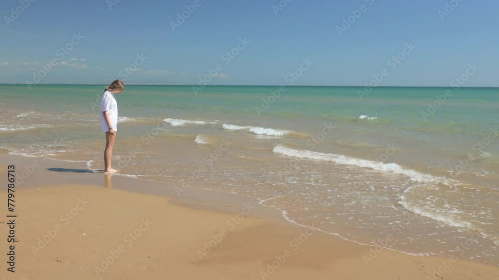 Beautiful girl teenage girl enjoys sea, her legs are caressed by waves of warm ocean enjoying sunbath at beach . Travel Holiday Trip.Tourist Sea Breeze Travel Summertime Vacation Vibes. Beautiful girl teenage girl enjoys sea, her legs are caressed by waves of warm ocean enjoying sunbath at beach . Travel Holiday Trip.Tourist Sea Breeze Travel Summertime Vacation Vibes.