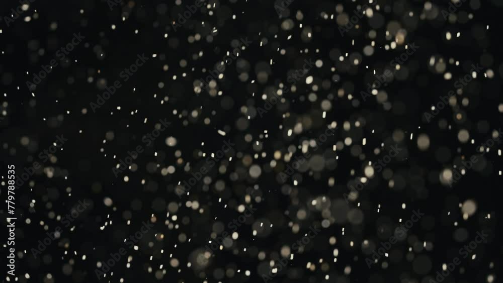 Extreme close up shot of wooden dust and particles after sawing wooden planks boards falling from above in the air, cinematic abstract background.
