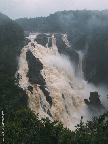 A waterfall with a misty  cloudy sky in the background