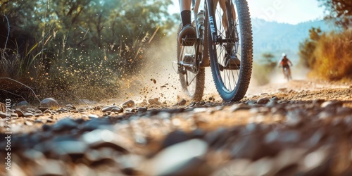 A man is riding a bike on a dirt road. The scene is lively and adventurous, with the man enjoying the thrill of riding on the rough terrain © kiimoshi
